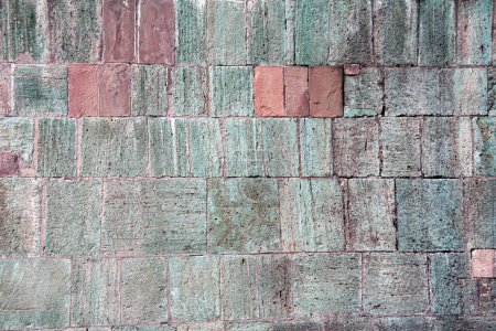 Foto de Texture of wall with stone blocks of red, green and gray colors. Horizontal background with decorative stone wall texture - Imagen libre de derechos