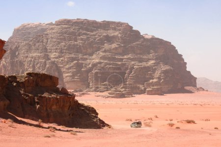 Téléchargez les photos : Car safari in Wadi Rum desert, Jordan. Tourists in car ride on off-road on sand among the beautiful rocks. Desert landscape with red sand and rocky mountains in Valley of the Moon - en image libre de droit