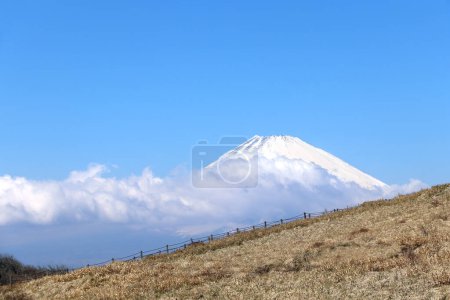 Photo for Beautiful sacred Mount Fuji (Fujiyama) in clouds on blue sky background, Japan. View from mount Komagatake - active volcano - Royalty Free Image