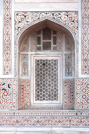 Foto de Arco del famoso mausoleo Itimad-ud-Daula, decorado con mosaicos de ámbar, cornalina, jaspe, lapislázuli, ónix, topacio y mármol. Antigua pared decorativa del ornamento, Agra, Uttar Pradesh, India - Imagen libre de derechos
