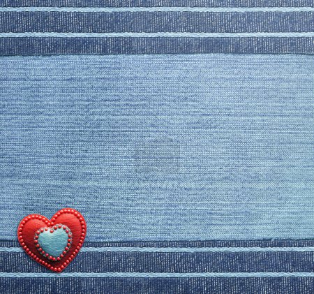 Photo for Blue denim background with striped borders and red felt heart. Navy color denim jeans fabric texture. Valentine's day denim backdrop. Copy space for text - Royalty Free Image