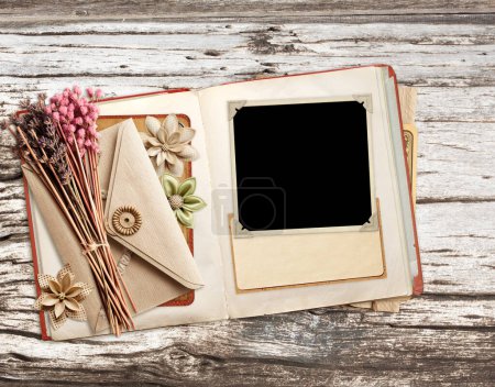 Photo for Retro book with photo, dry leaf, vintage envelope and paper card on old wooden board. Nostalgic scrapbooking backdrop. Mockup template. Copy space for text - Royalty Free Image