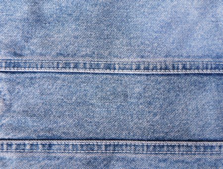 Téléchargez les photos : Fond en denim bleu avec une couture. Texture en jean denim bleu clair. Espace de copie pour le texte - en image libre de droit