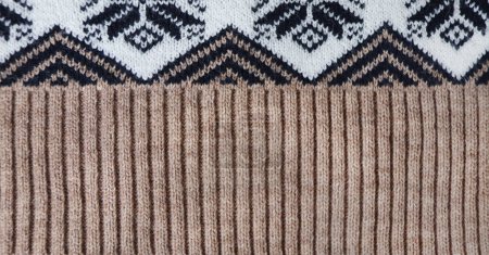 Foto de Jersey de lana textura de color marrón claro, marrón oscuro y blanco con adorno geométrico. Material de lana natural de punto con adorno decorativo. Fondo horizontal con textura de tejido de punto - Imagen libre de derechos