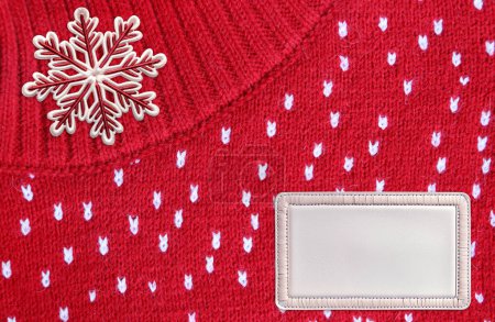 Téléchargez les photos : Fond horizontal de Noël avec texture tricotée, feutre flocons de neige et étiquette en cuir. Pull en laine texture de couleur rouge avec pointillés blancs. Modèle maquillé. Espace de copie pour le texte - en image libre de droit
