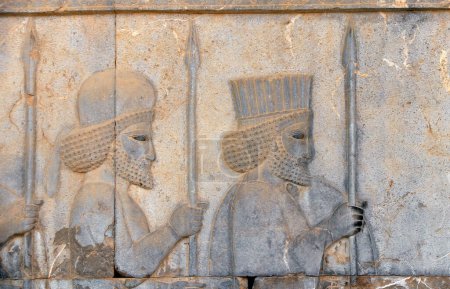 Photo for Ancient wall with bas-relief with two assyrian warriors with spears, Persepolis, Iran. UNESCO world heritage site - Royalty Free Image