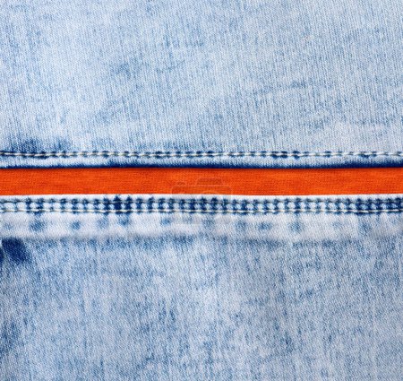 Foto de Fronteras de mezclilla azul con una costura y textura de algodón naranja. Tejido vaquero de color azul claro y naranja. Copiar espacio para texto - Imagen libre de derechos