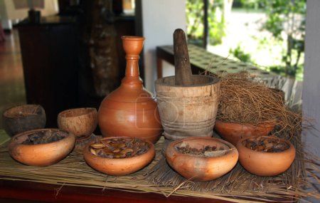 Téléchargez les photos : Pot d'argile et bols avec des ingrédients naturels du traitement ayurvédique, Sri Lanka. Concept de traitement à base de plantes - en image libre de droit