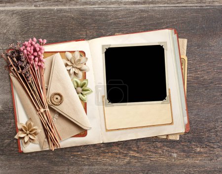 Photo for Retro book with photo, dry leaf, vintage envelope and paper card on old wooden board. Nostalgic scrapbooking backdrop. Mockup template. Copy space for text - Royalty Free Image
