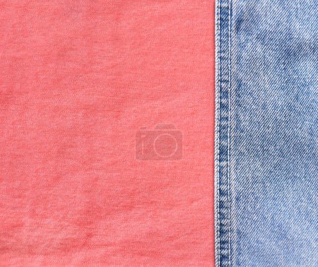 Téléchargez les photos : Bordures en denim bleu avec une couture et une texture en coton corail. Tissu jean denim bleu clair et rose. Espace de copie pour le texte - en image libre de droit