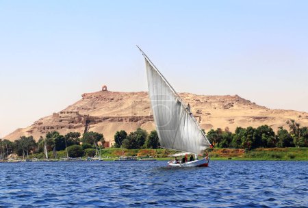Photo for Traditional sailing boat felucca, Nile river near Aswan, Egypt. A famous tourist attraction - sailing boat ride - Royalty Free Image