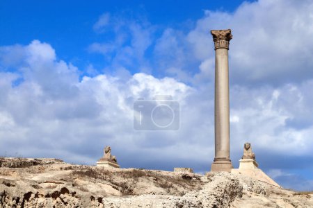 Foto de Monumento famoso - Serapeum de Alejandría. Two Sphinx and Pompey's Pillar in Alexandria, Egypt, North Africa. Serapeum templo romano con pilar de Pompeyo y esfinges - Imagen libre de derechos