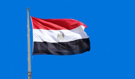 Photo for Flag of Egypt waving in the wind. Flag of the Arab Republic of Egypt on flagpole on blue sky background - Royalty Free Image