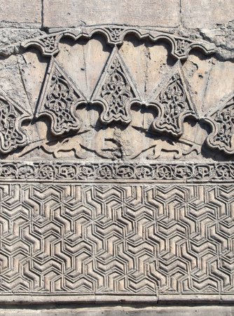 Téléchargez les photos : Fond rétro avec ornement ancien en pierre sculptée. Basse-relief en pierre géométrique avec ornement islamique traditionnel. Ornement oriental sur mur de pierre médiéval - en image libre de droit