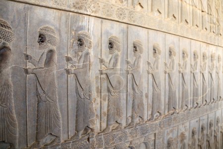 Téléchargez les photos : Ancien mur avec bas-relief avec guerriers assyriens avec lances, Persépolis, Iran - en image libre de droit