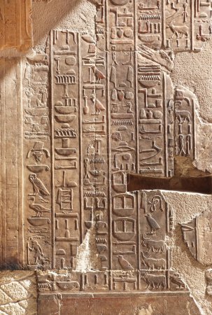 Photo for Ancient Egyptian hieroglyphs on stone wall inside Hatshepsut Temple in Valley of the Kings, Luxor, Egypt. Stone carvings with hieroglyphs, wall of the Hatshepsut temple in Western Thebes - Royalty Free Image