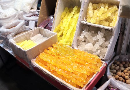Téléchargez les photos : Persian Saffron Rock Candy Nabat sur le marché de rue. Sucre cristallisé au safran - dessert traditionnel roumain. Vente de cristal de sucre de sucre de roche safran, Iran - en image libre de droit