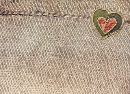 Foto de Dos piezas de arpillera vieja cosidas juntas con hilo y corazón de tela. Fondo horizontal con textura de bolsa rústica y decoración de San Valentín en estilo patchwork. Copiar espacio para texto - Imagen libre de derechos