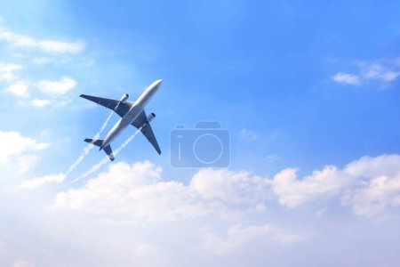 Horizontal nature background with aircraft and Jet trailing smoke in the sky. Airplane and condensation trail. Foggy trail jet and plane in blue sky with white clouds. Traveling the world concept
