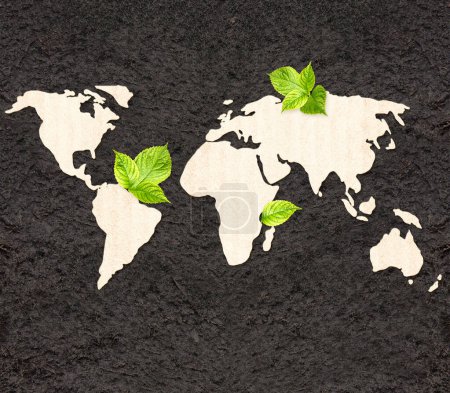 Téléchargez les photos : Écologie et concept zéro déchet. Carte du monde silhouette en carton et feuilles vertes sur sol noir. Bannière horizontale avec texture éco-papier. Ressources écologiques mondiales. Espace de copie pour le texte - en image libre de droit