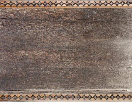 Téléchargez les photos : Texture de planches de bois vintage avec bordure décorative sculptée. Arrière-plan rétro vertical ou horizontal avec de vieilles planches en bois et ornement géométrique. Modèle maquillé. Espace de copie pour le texte - en image libre de droit