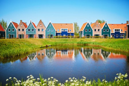 Foto de Coloridas casas reflejadas en el agua en el parque marino de Volendam. Paisaje típico holandés en Holanda Septentrional, Holanda. - Imagen libre de derechos