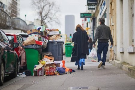 Photo for Paris, France - March 12, 2023: Messy streets with overfull garbage bins during binmen strike in Paris, France - Royalty Free Image