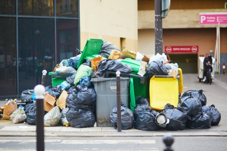 Photo for Paris, France - March 16, 2023: Messy streets with overfull garbage bins during binmen strike in Paris, France. - Royalty Free Image
