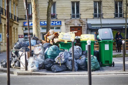 Photo for Paris, France - March 16, 2023: Messy streets with overfull garbage bins during binmen strike in Paris, France. - Royalty Free Image