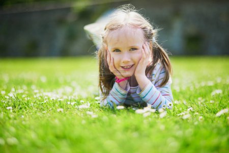 Téléchargez les photos : Joyeux joyeux préscolaire fille marche dans le parc. Activités d'été en plein air pour les enfants - en image libre de droit