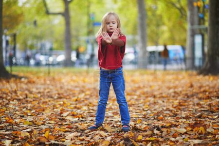 Téléchargez les photos : Moody enfant d'âge préscolaire au jour d'automne en plein air. Enfant malheureux dans un parc à Paris, France. Concept de tantrum pour enfants - en image libre de droit