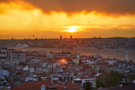 Téléchargez les photos : Vue panoramique du quartier d'Uskudar du côté asiatique d'Istanbul, Turquie avec la mosquée bleue et Hagia Sophia à l'horizon sur le détroit du Bosphore avec un ciel spectaculaire pendant le coucher du soleil - en image libre de droit