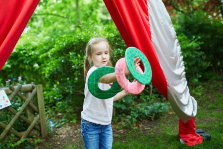 Photo for Preschooler girl practicing spinning circus skills outdoors - Royalty Free Image