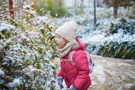 Photo for Adorable preschooler girl having fun in beautiful winter park on a snowy cold winter day. Cute child playing in snow. Winter activities for family with kids - Royalty Free Image