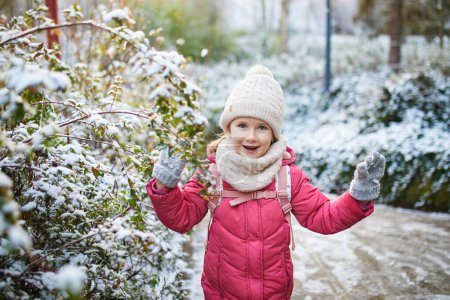 Photo for Adorable preschooler girl having fun in beautiful winter park on a snowy cold winter day. Cute child playing in snow. Winter activities for family with kids - Royalty Free Image