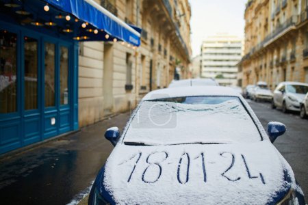 Photo for Car rear window covered with snow with date of snowfall written on it. Snowy day in Paris, France - Royalty Free Image