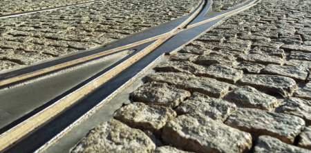 Foto de Pistas de tranvía divididas en la superficie de piedra de la carretera. - Imagen libre de derechos