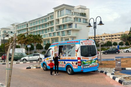 Foto de CHIPRE, PAPHOS-22 MARZO: Paphos es una ciudad costera en el suroeste de Chipre, situada en la costa mediterránea. A view of the ice cream bus on the footpath on March 22, 2023, Paphos, Cyprus. - Imagen libre de derechos