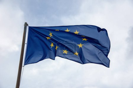 Foto de Bandera de la UE ondeando contra un cielo nublado. - Imagen libre de derechos