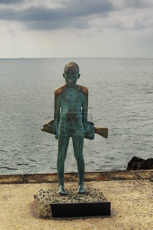 Foto de CHIPRE, PAPHOS-22 MARZO: Paphos es una ciudad costera en el suroeste de Chipre, se encuentra en la costa mediterránea. Vista de la escultura de pescador el 22 de marzo de 2023, Chipre, Paphos. - Imagen libre de derechos