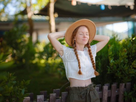 Photo for Caucasian ginger young beautiful woman in hat traveling alone. Attractive traveler look around and explore while walk in nature wood with happiness and fun during holiday vacation trip. - Royalty Free Image