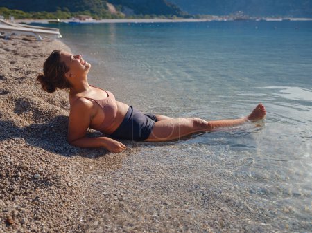 Téléchargez les photos : Cheerful woman enjoying the beach Oludeniz Blue Lagoon Turkey. Life of people xl size, happy nice natural beauty woman - en image libre de droit