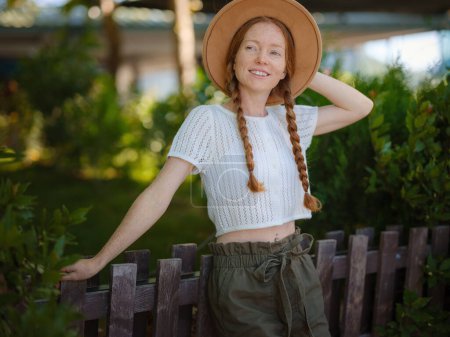Photo for Caucasian ginger young beautiful woman in hat traveling alone. Attractive traveler look around and explore while walk in nature wood with happiness and fun during holiday vacation trip. - Royalty Free Image