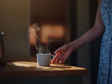 Photo for Woman is drinking coffee , morning routine. Tiny house. First property. Small apartment interior design. Minimalism. Moving in. Living alone. Charming trailer house with the morning sun - Royalty Free Image