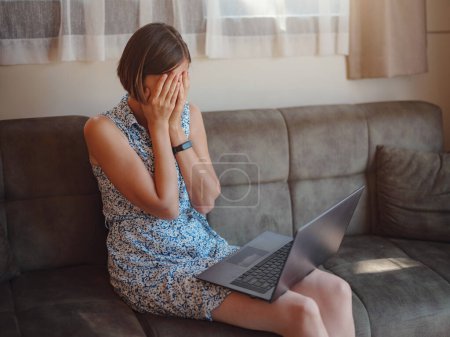 Photo for Stressed asian woman read bad news from laptop computer. Tired freelancer suffer from headache pain, remote work concept. Tiny houses and Small Living concept. - Royalty Free Image