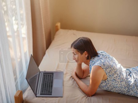 Photo for Happy young asian woman with laptop resting in bedroom in tiny house, weekend away and remote office idea. Tiny houses and Small Living concept. - Royalty Free Image