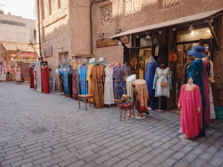 Téléchargez les photos : 20 mars 2023, Dubaï, Émirats arabes unis : Le vieux village d'Al Seef à Dubaï, vieux souk traditionnel avec des robes et d'autres vêtements. - en image libre de droit