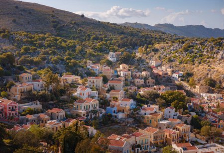 Symi Island, Greece. Greece islands holidays from Rhodos in Aegean Sea. Colorful neoclassical beautiful houses on hillsides of a Greek island during sunset. Holiday travel background.