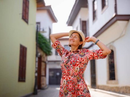 female summer travel to Antalya, Turkey. young asian woman in red dress walk through old town Kalechi , female tourist traveler discover interesting places and popular tourist attraction