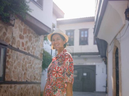 viajes de verano femenino a Antalya, Turquía. joven mujer asiática en vestido rojo caminar por el casco antiguo de Kalechi, viajero turístico femenino descubrir lugares interesantes y popular atracción turística